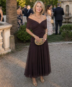 Woman wearing a purple off-shoulder draped midi dress - studio photo