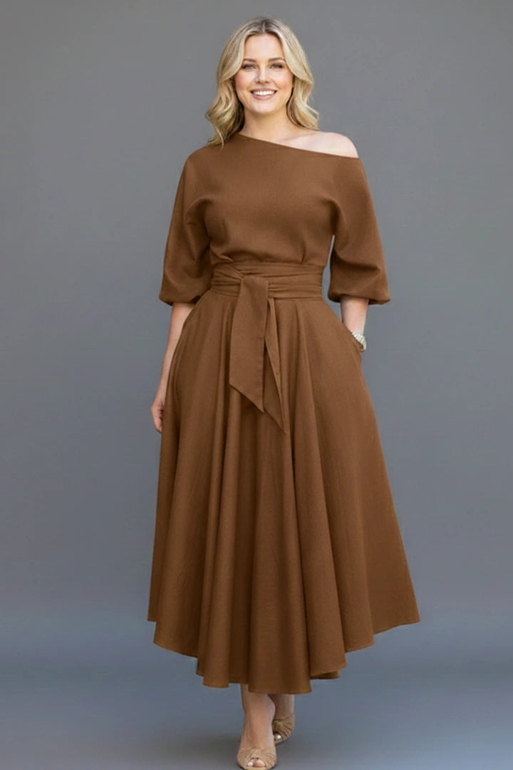 Woman wearing a khaki off-shoulder lantern sleeve midi dress - studio photo