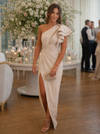 Woman wearing a beige one shoulder draped midi dress - editorial style photo