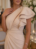 Woman wearing a beige one shoulder draped midi dress - studio photo