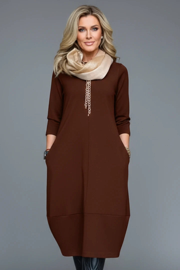 Woman wearing a brown round neck pocket midi dress - studio photo