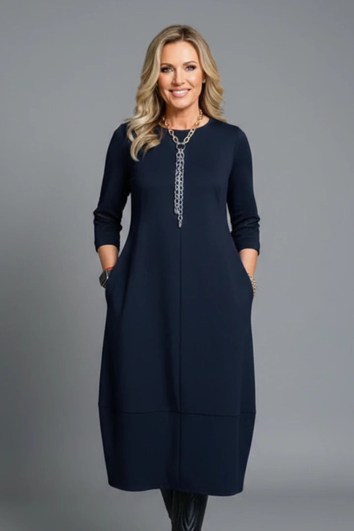 Woman wearing a navy blue round neck pocket midi dress - studio photo