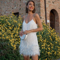 Woman wearing a white sequin spaghetti strap fitted dress - editorial style photo