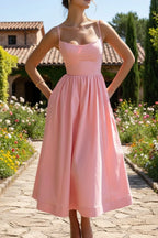 Woman wearing a pink sleeveless cocktail midi dress - outdoor lifestyle photo