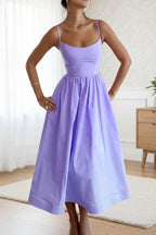 Woman wearing a purple sleeveless cocktail midi dress - outdoor lifestyle photo