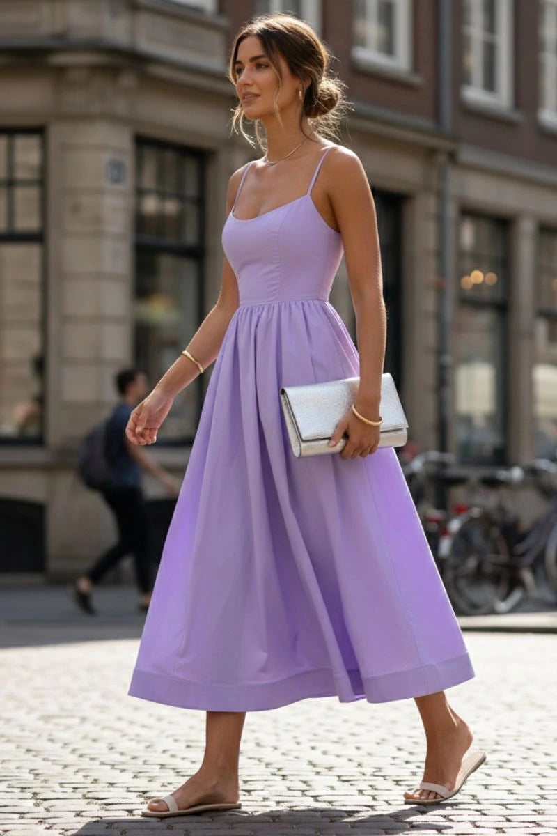 Woman wearing a purple sleeveless cocktail midi dress - outdoor lifestyle photo