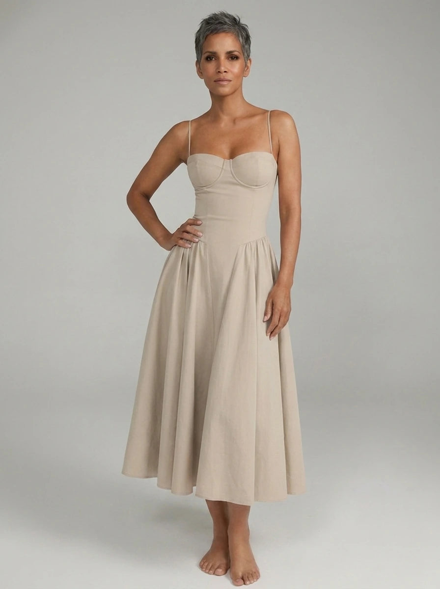 Woman wearing a beige sleeveless corset style midi dress, studio photo, hand on hip pose