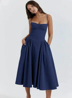 Woman wearing a blue sleeveless corset style midi dress - studio photo