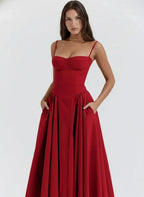 Woman wearing a red sleeveless corset style midi dress - studio photo