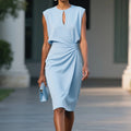 Woman wearing a light blue sleeveless elegant midi dress - studio photo
