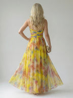 Woman wearing a yellow soft wrap maxi dress - studio photo