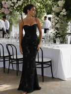 Woman wearing a black spaghetti strap corset maxi dress - studio photo
