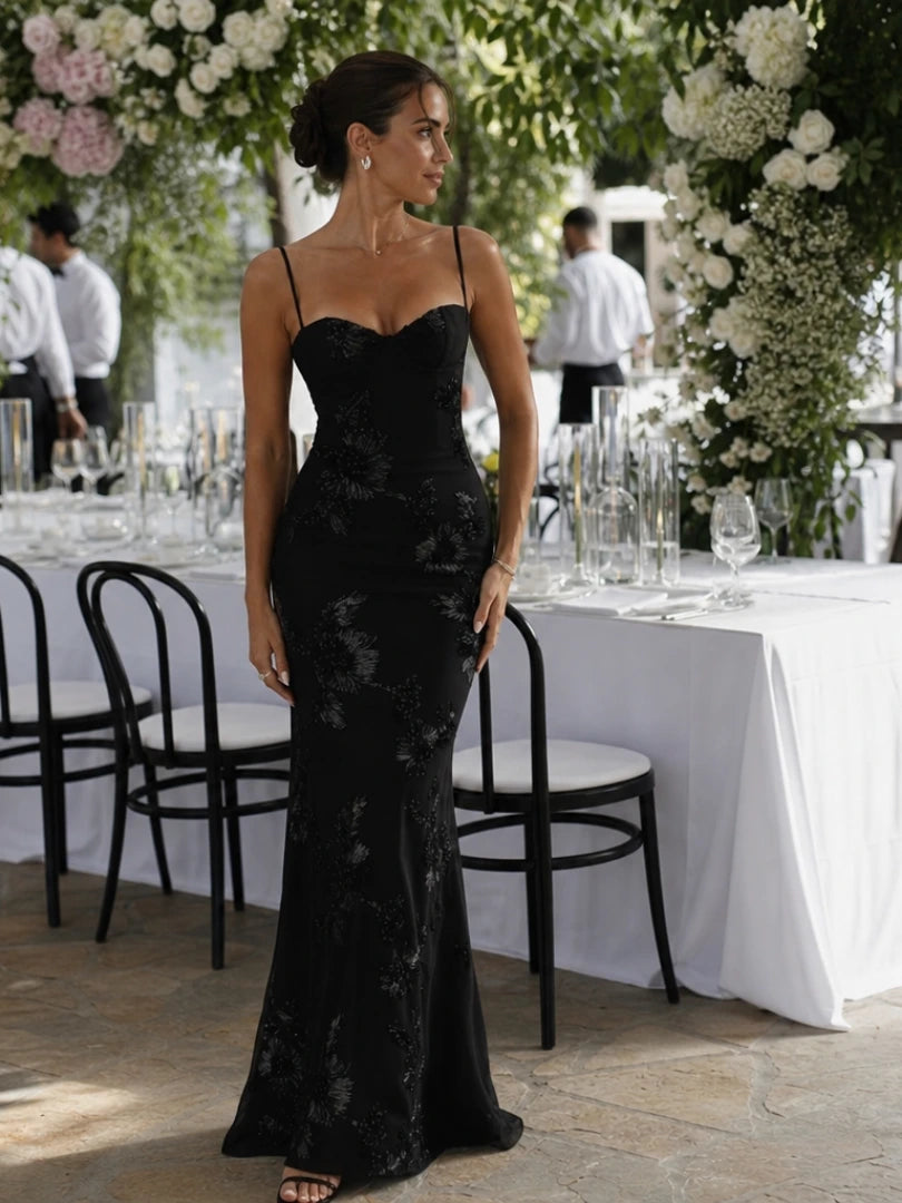 Woman wearing a black spaghetti strap corset maxi dress - studio photo