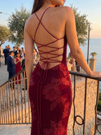 Woman wearing a burgundy spaghetti strap corset maxi dress - editorial style photo
