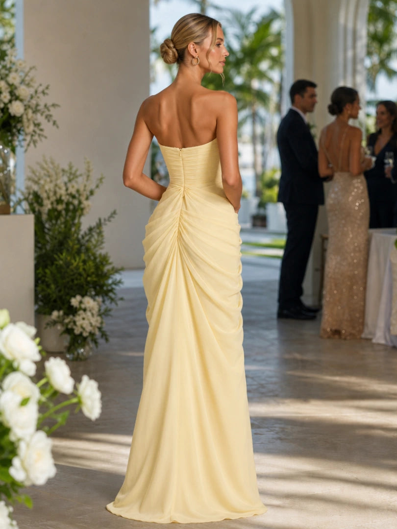 Woman wearing a yellow strapless high side slit maxi dress - studio photo
