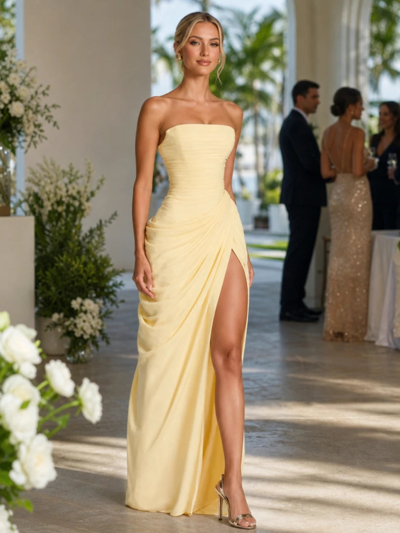 Woman wearing a yellow strapless high side slit maxi dress - studio photo