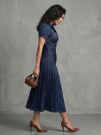 Woman wearing a blue stripe pleated midi dress - studio photo