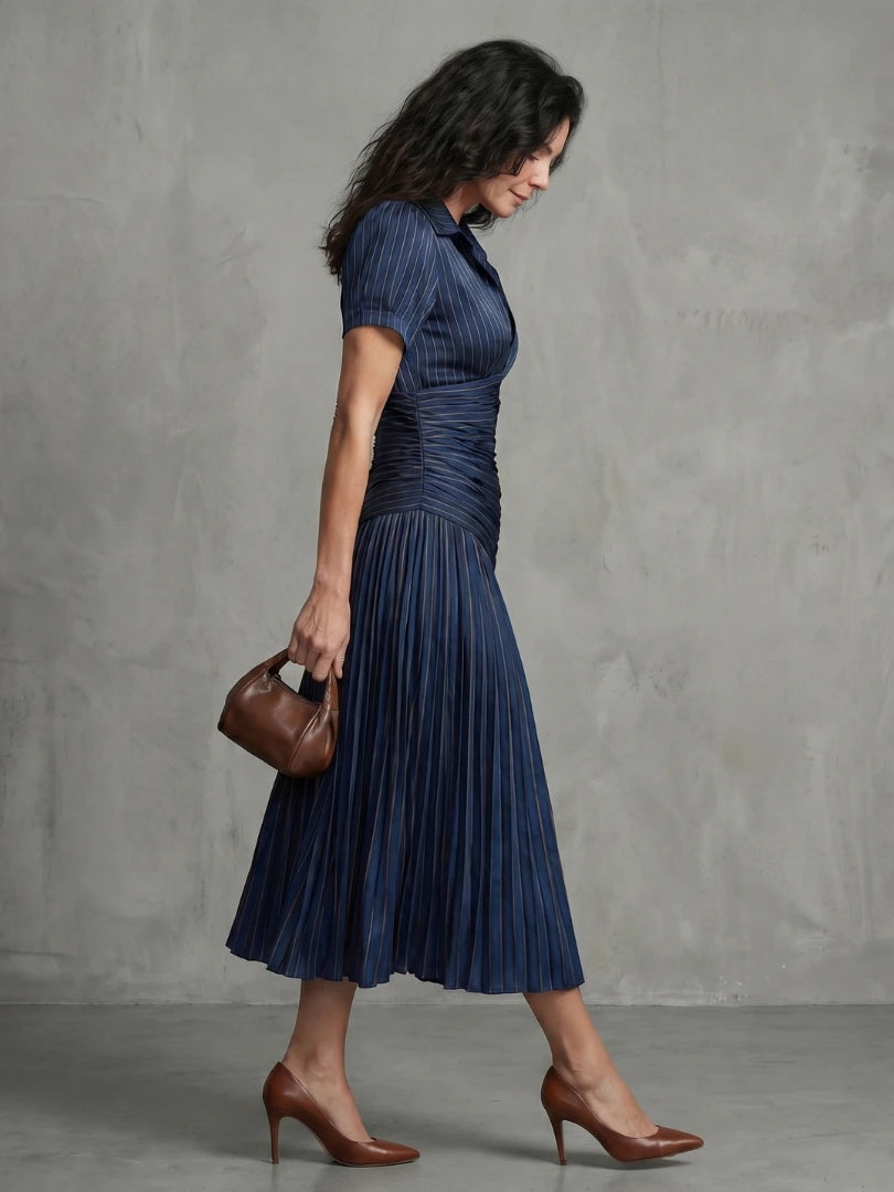 Woman wearing a blue stripe pleated midi dress - studio photo