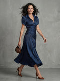 Woman wearing a blue stripe pleated midi dress - studio photo