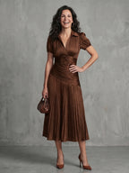 Woman wearing a brown stripe pleated midi dress - studio photo