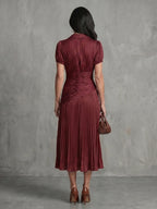 Woman wearing a brown stripe pleated midi dress - studio photo