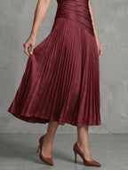 Woman wearing a red stripe pleated midi dress - studio photo