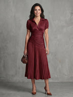 Woman wearing a red stripe pleated midi dress - studio photo