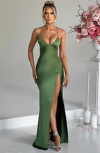 Woman wearing a emerald thin strap high slit maxi dress - studio photo
