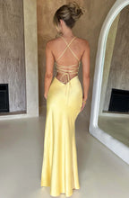 Woman wearing a yellow thin strap high slit maxi dress - studio photo