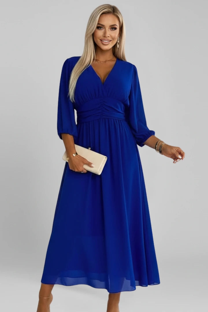 Woman wearing a blue v-neck wrap waist dress - studio photo