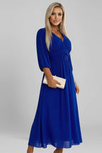 Woman wearing a blue v-neck wrap waist dress - studio photo