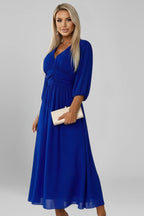 Woman wearing a blue v-neck wrap waist dress - studio photo