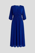 Woman wearing a blue v-neck wrap waist dress - studio photo