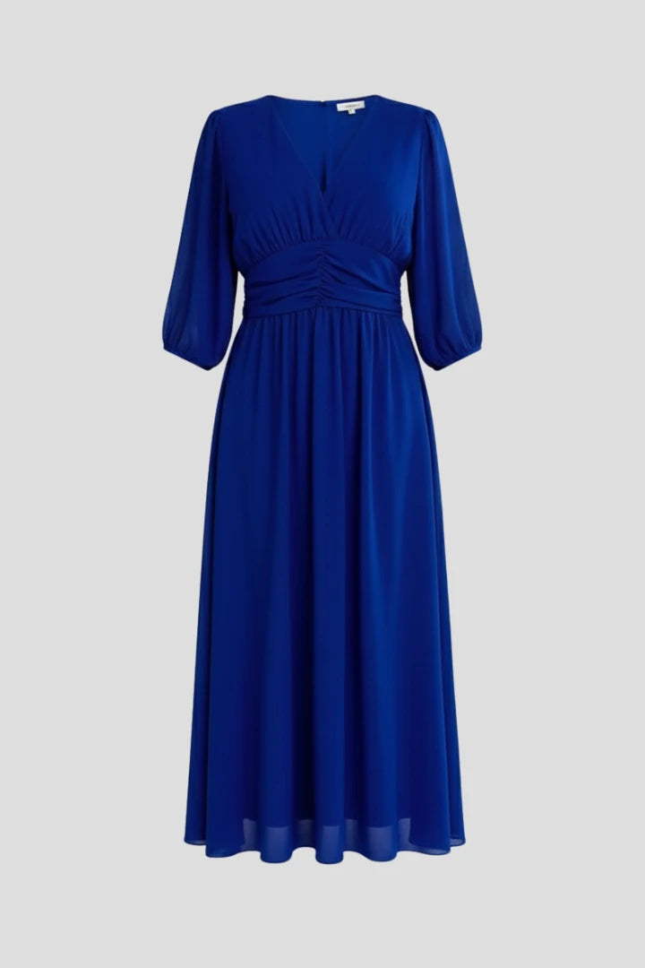 Woman wearing a blue v-neck wrap waist dress - studio photo