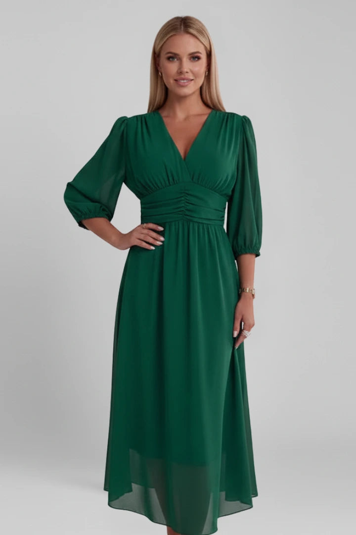 Woman wearing a green v-neck wrap waist dress - studio photo