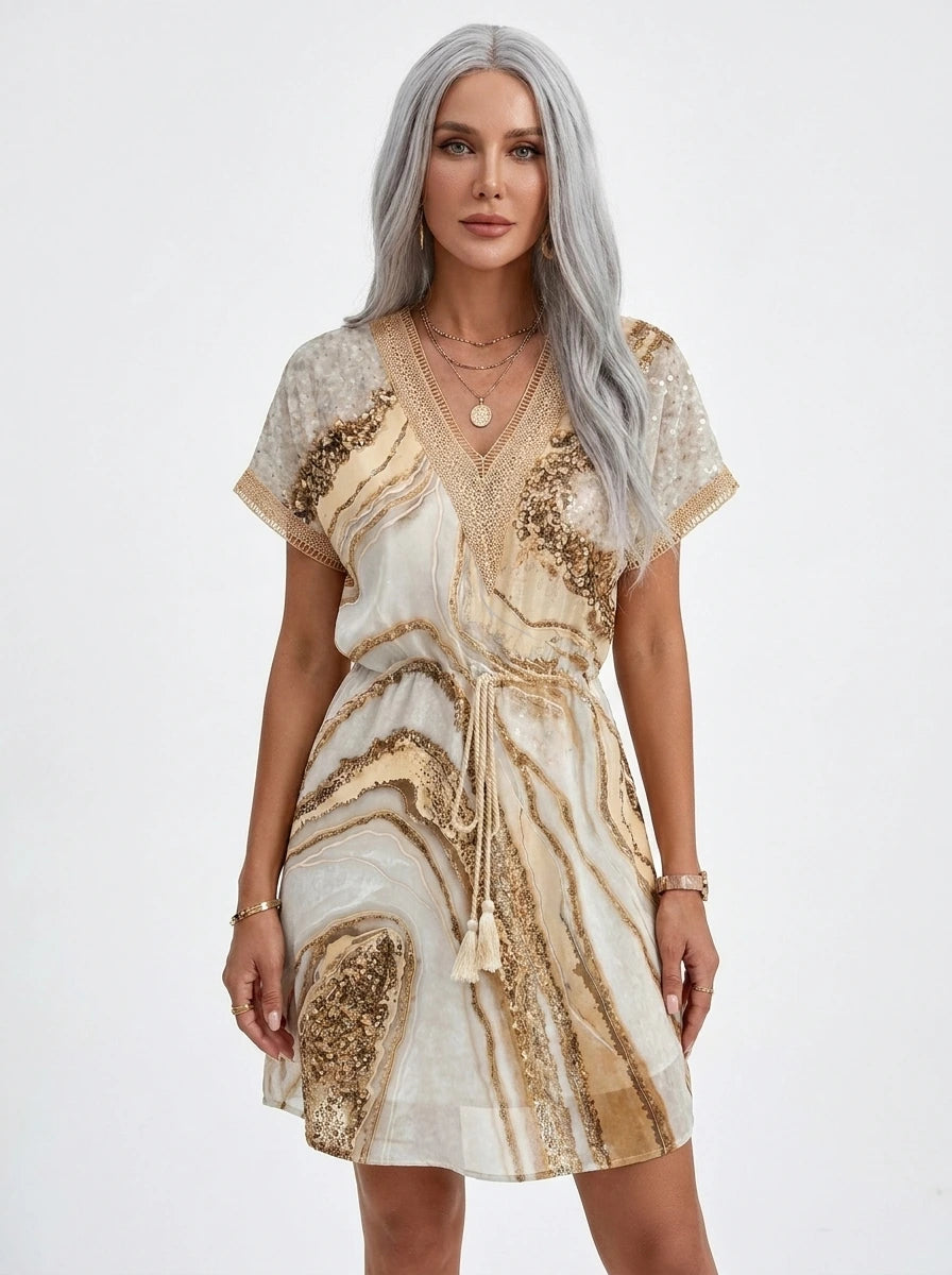 Woman wearing a gold and cream marbled sequin boho dress in a bright studio setting
