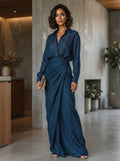 Woman wearing a dark blue elegant long-sleeve wrap maxi dress, indoor setting