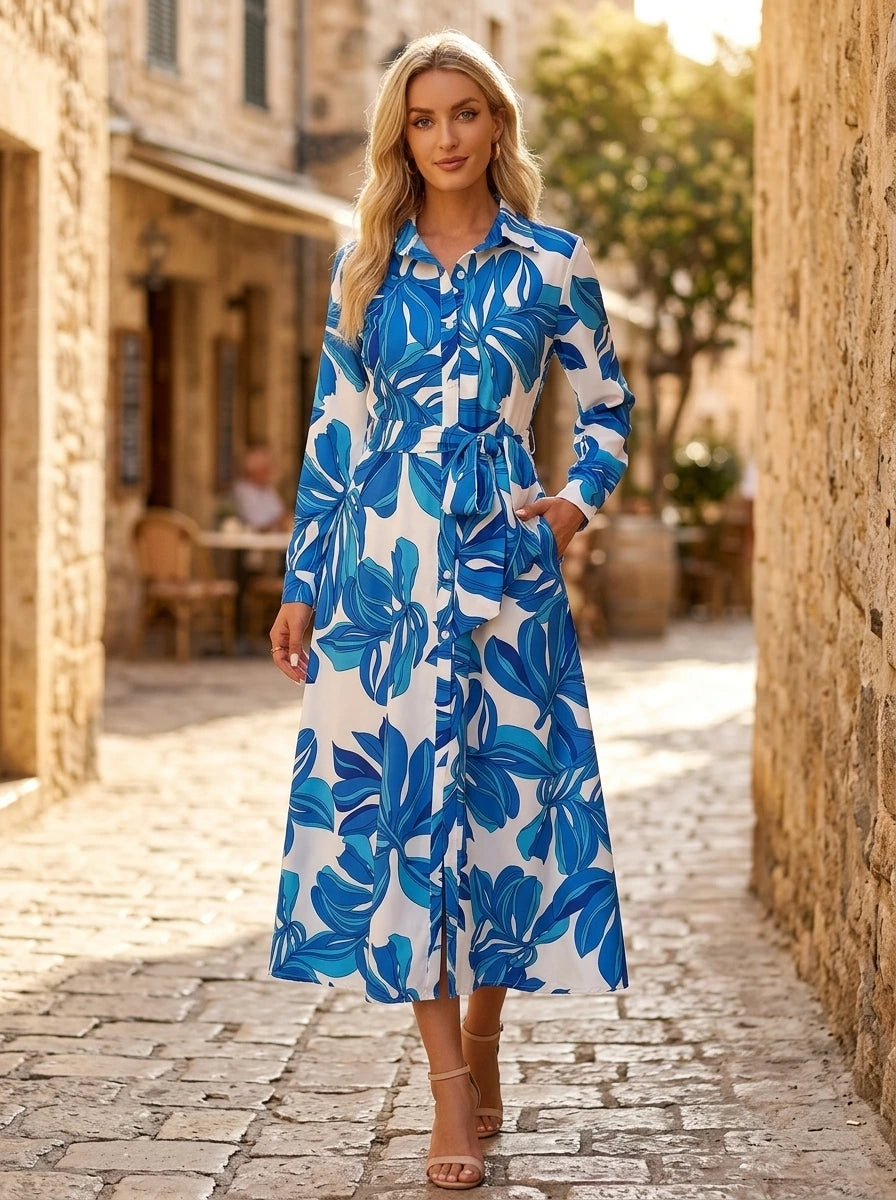 Driftly blue floral button-down midi dress with lapel collar, long sleeves, and adjustable waist tie, on a European street at golden hour.
