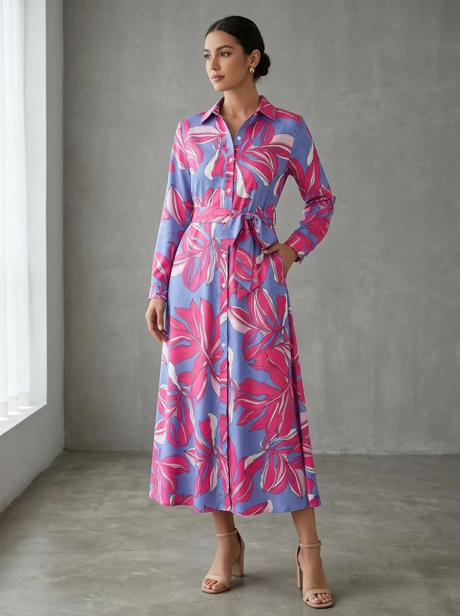 Driftly pink floral button-down midi dress with lapel collar, long sleeves, and adjustable waist tie, in a minimalist studio setting with soft window light.