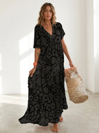 Driftly black floral V-neck midi dress, bohemian style, soft-blend fabric, in a minimalist studio setting with soft window light.