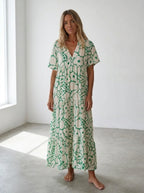 Driftly green floral V-neck midi dress, bohemian style, soft-blend fabric, in a minimalist studio setting with soft window light.