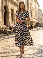 Driftly women's black and white geometric print V-neck A-line maxi dress, walking on a European street at golden hour.
