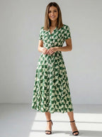 Driftly women's green geometric print V-neck A-line maxi dress, in a minimalist studio setting.