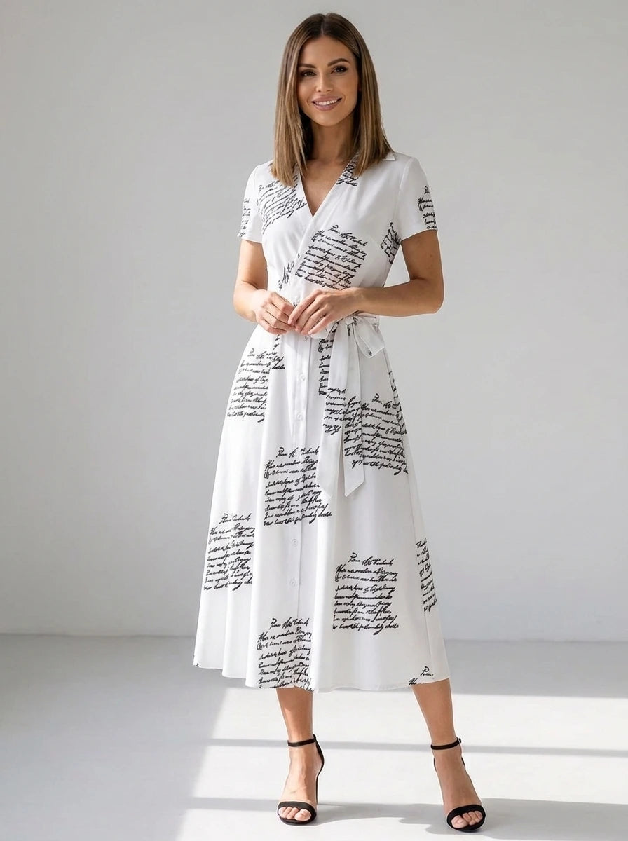 Driftly women's white V-neck A-line maxi dress with black script print, in a minimalist studio setting.