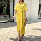 Woman wearing a yellow wrap short sleeve midi dress - outdoor lifestyle photo