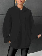 Woman wearing black oversized cable-knit hoodie with drawstring
