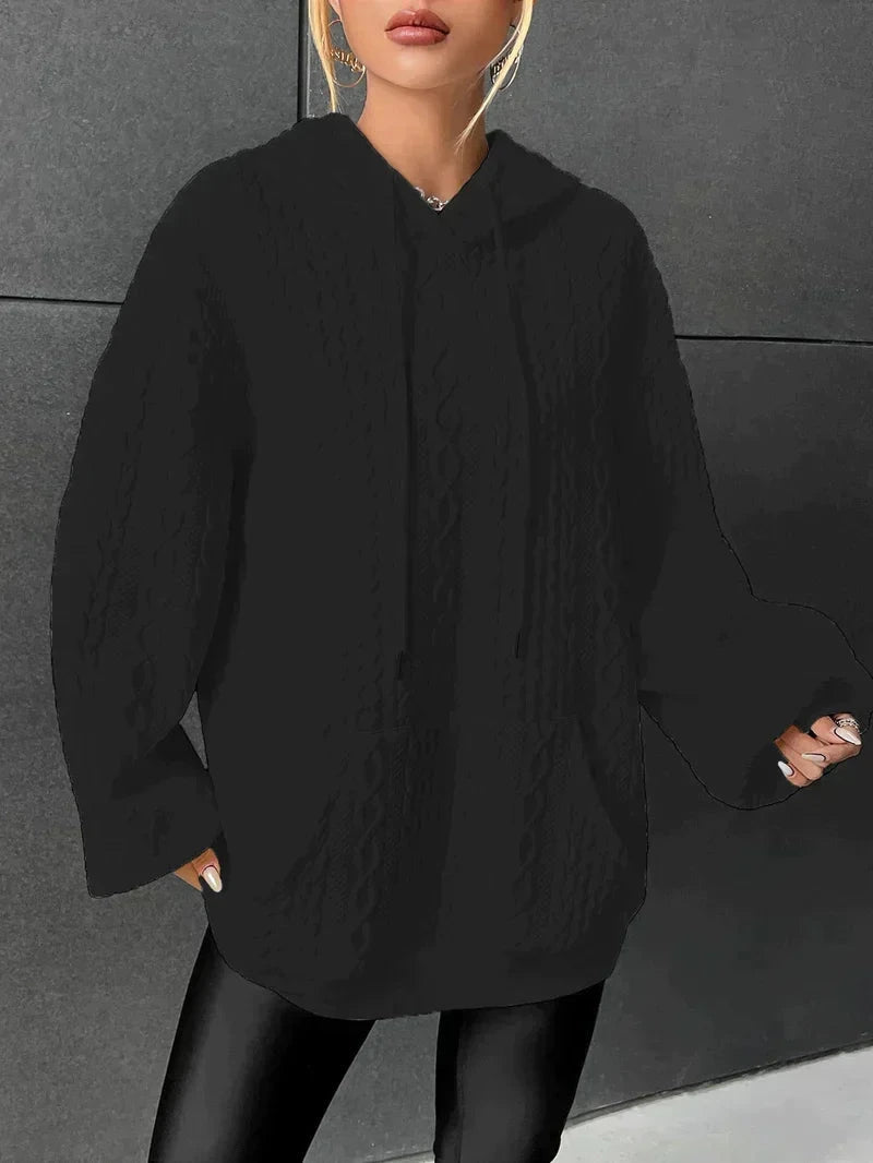 Woman wearing black oversized cable-knit hoodie with drawstring