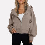 Woman wearing a taupe cropped zip hoodie in a studio setting
