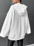 Woman wearing white oversized cable-knit hoodie with drawstring, back view