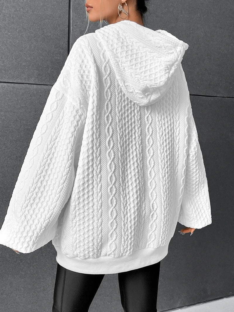 Woman wearing white oversized cable-knit hoodie with drawstring, back view